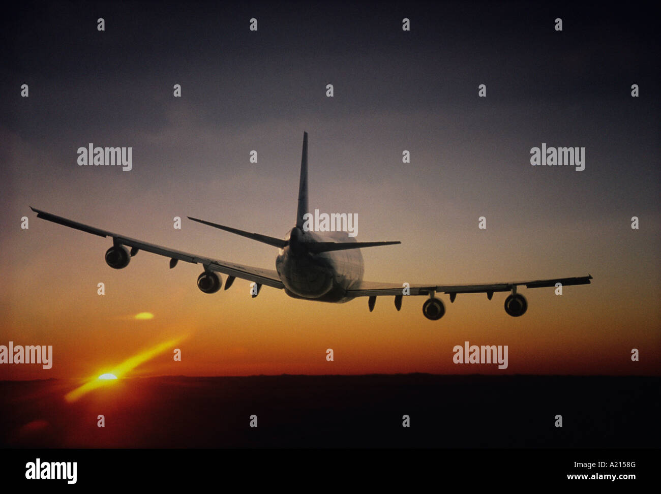 Plane Flying, sun setting on horizon, back view Stock Photo - Alamy