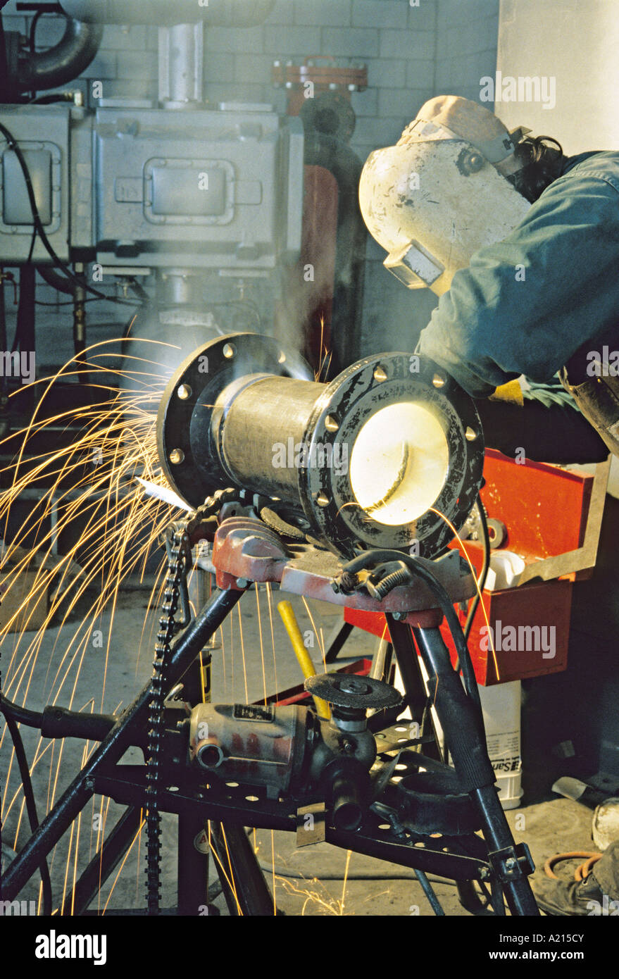 pipe fitter grinding pipe in factory construction site Stock Photo