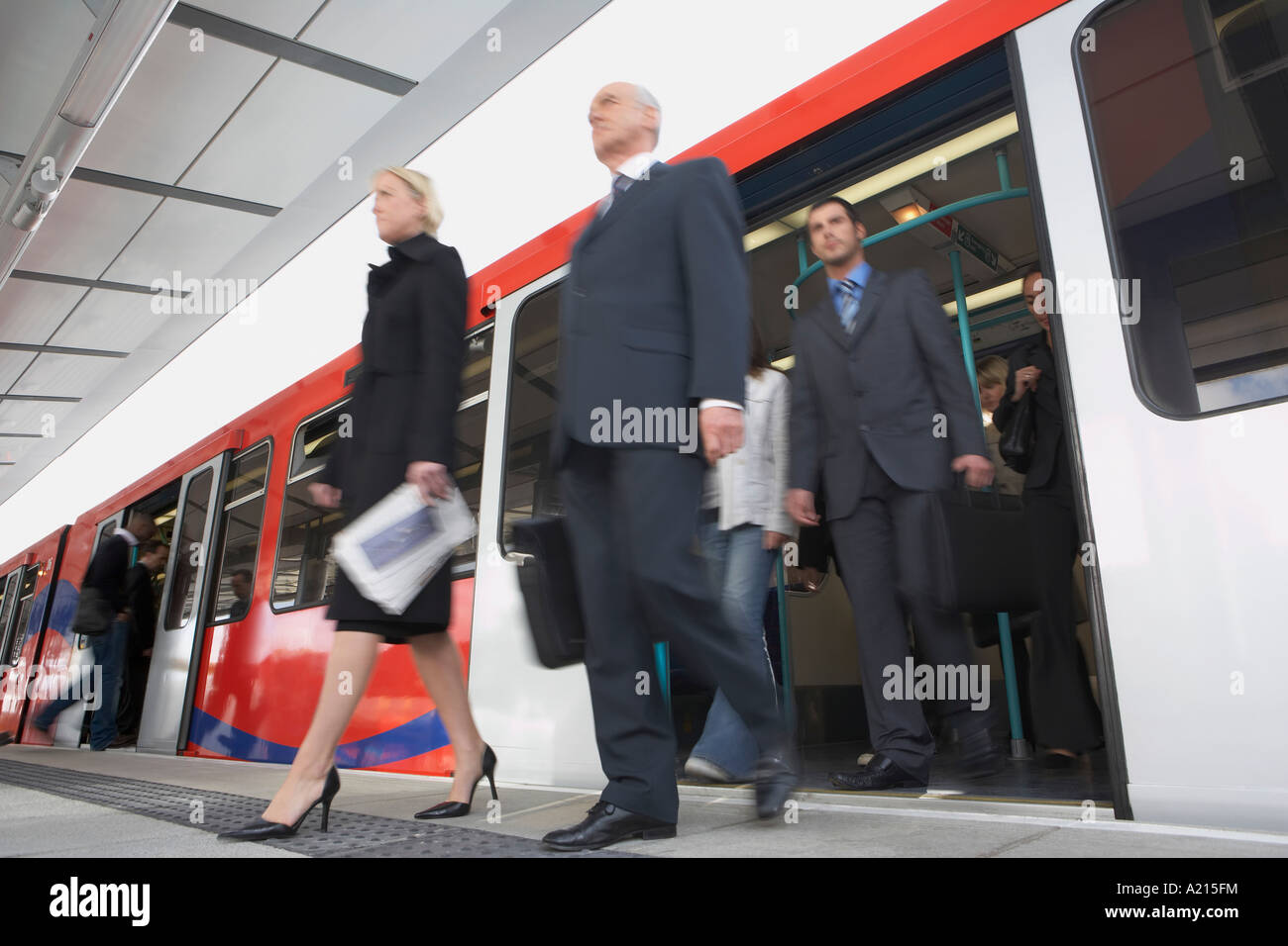 Business Commuters Getting off a Train, motion blur, low angle view Stock Photo