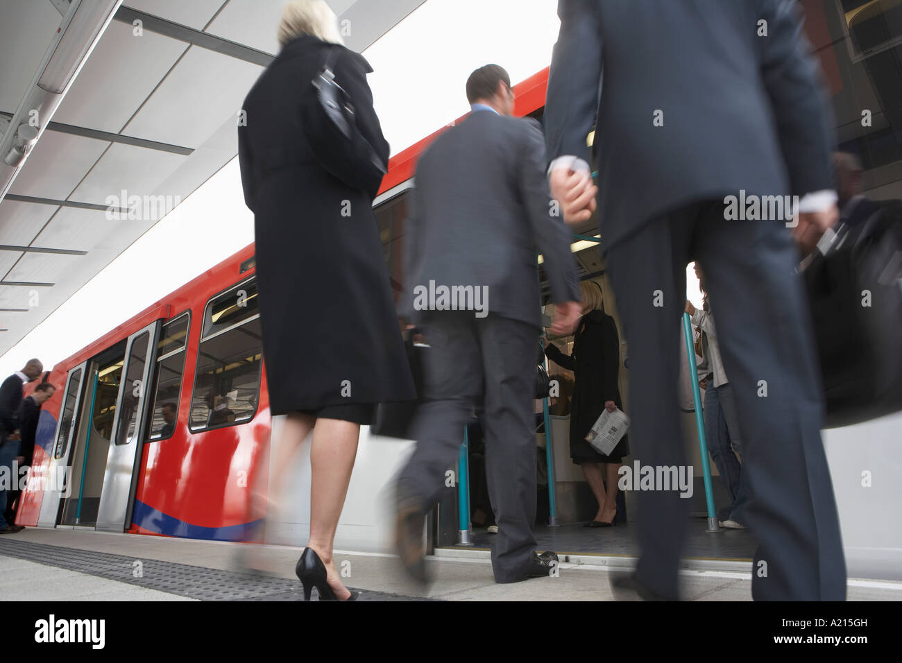 Business Commuters Getting on Train, motion blur, low angle view Stock Photo