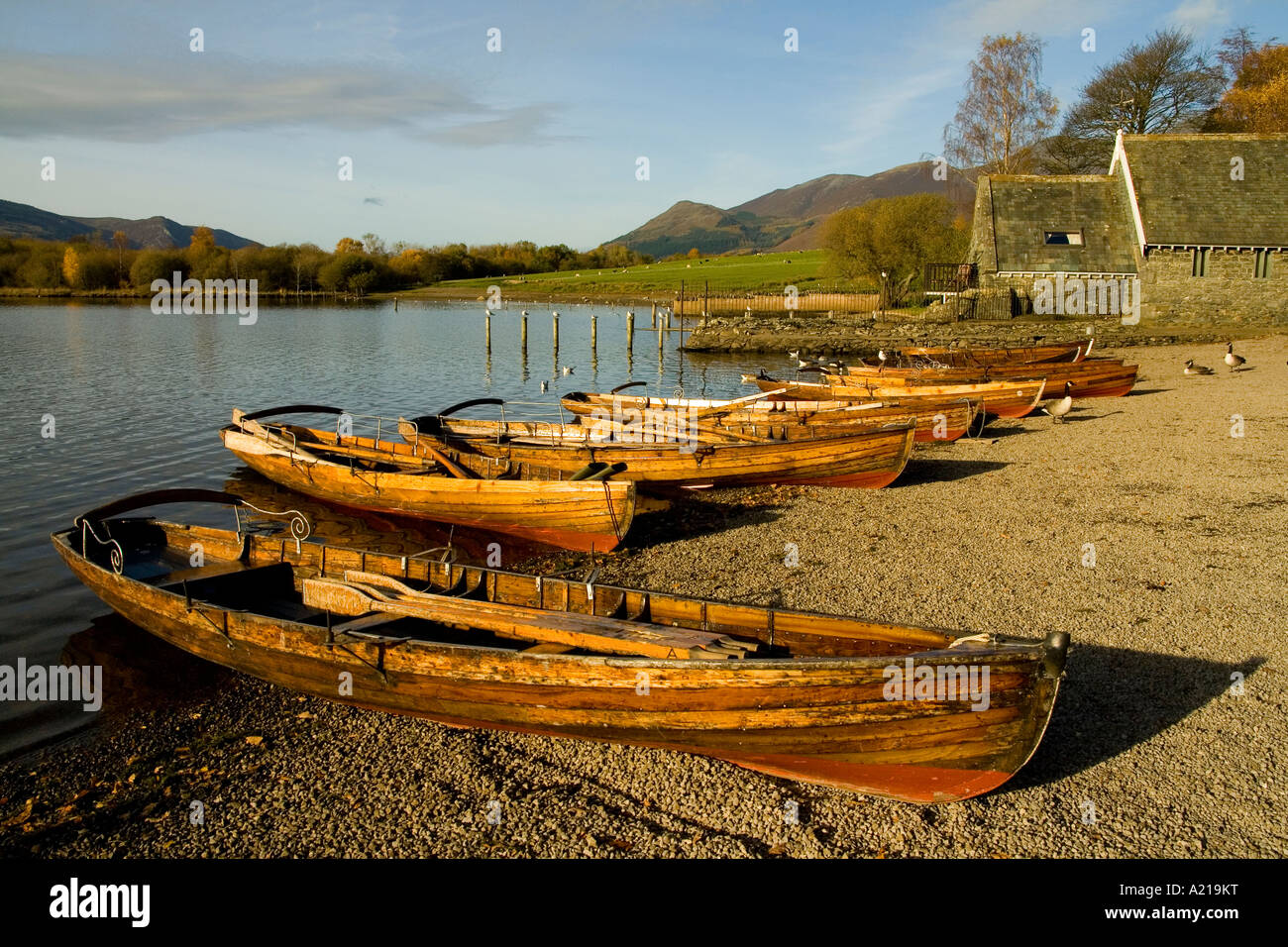 Golden hour sun lit boats at Derwent Water in the Lake district near Kewsick Stock Photo