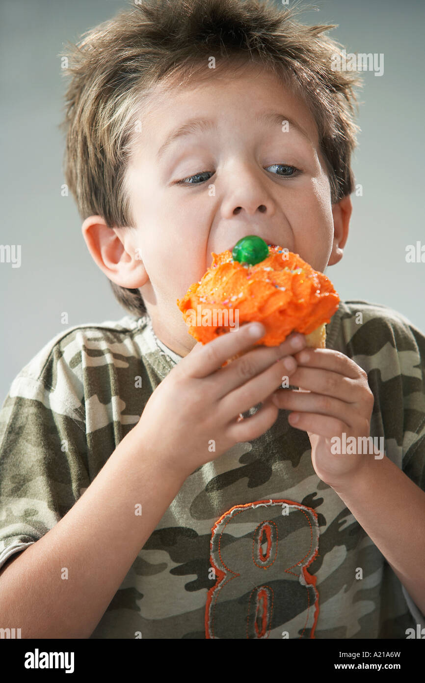 Young boy eating cupcake Stock Photo - Alamy
