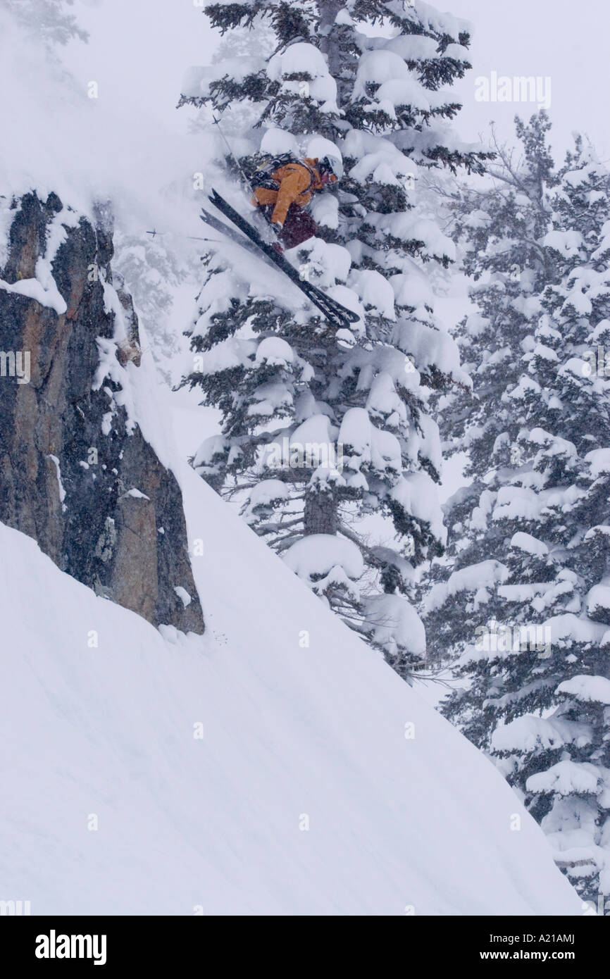 A man skiing off a cliff in deep powder snow in a storm at Alpine Meadows in Lake Tahoe