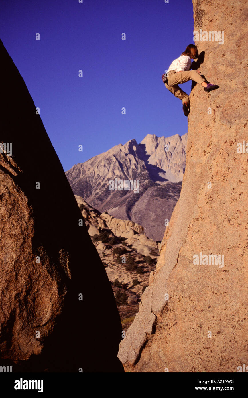 A woman rock climbing in the Buttermilk boulders near California