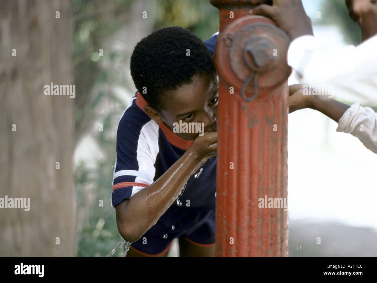 a child drinking water from a fire hydrant, St Anne's Bay, Jamaica