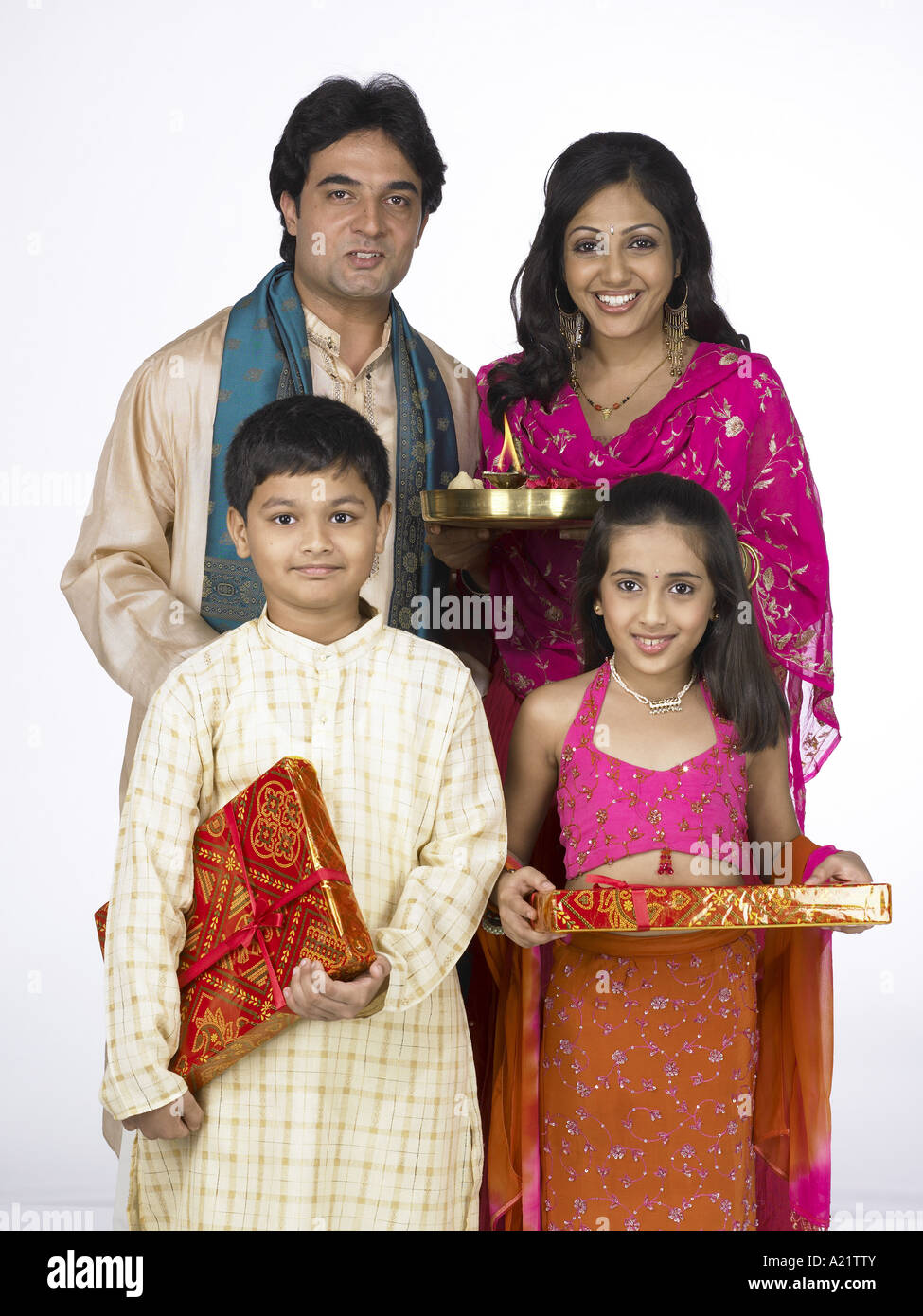 South Asian Indian family standing holding Arati thali packet and Stock