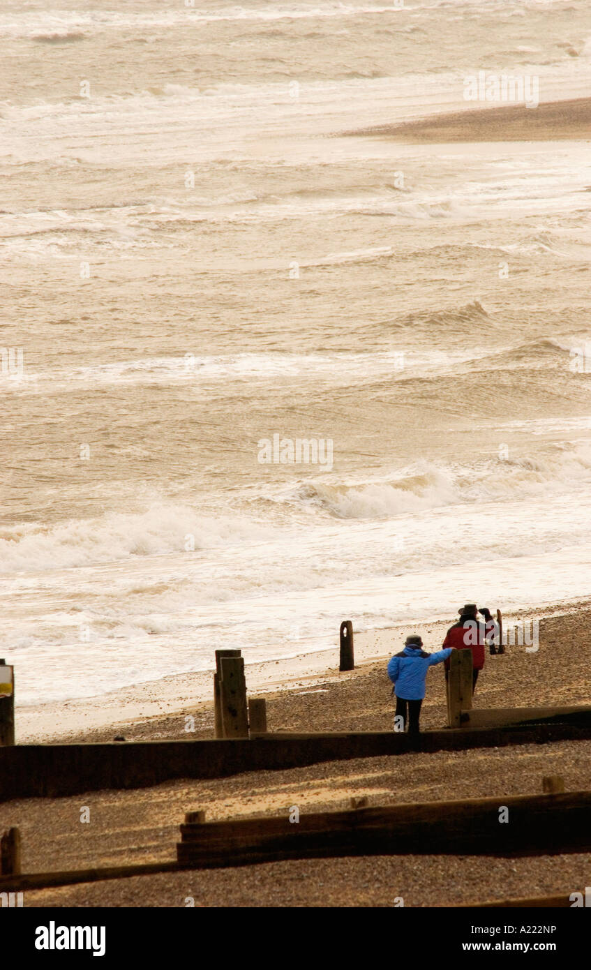 Two people walking along beach in Suffolk Stock Photo - Alamy