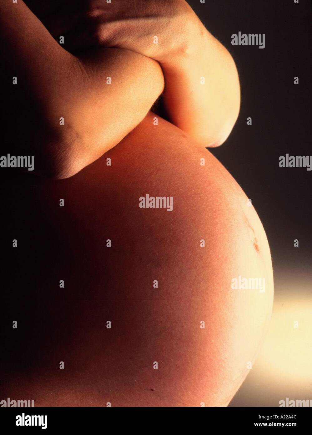 Close up of a woman s stomach at nine months pregnant J Miller Stock Photo