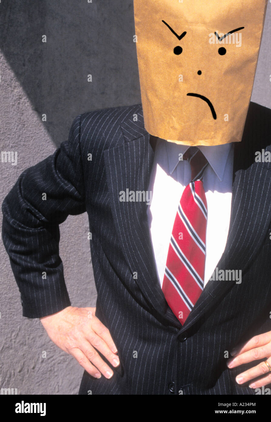 Businessman with brown paper bag over his head frowning and dissatisfied Stock Photo