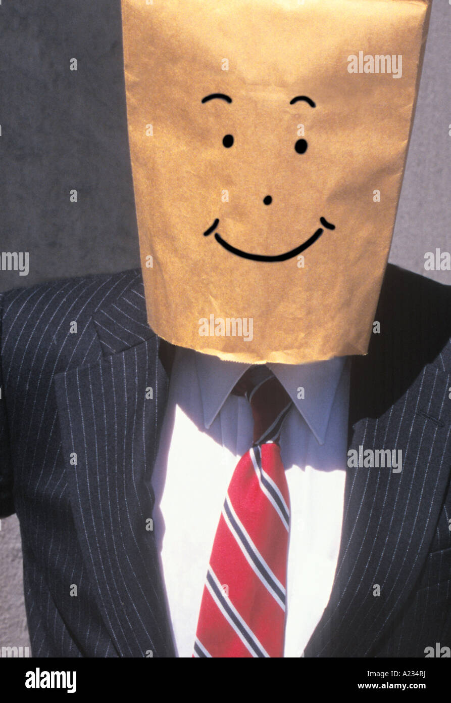 Businessman With Brown Paper Bag Over His Head Smiling Stock Photo