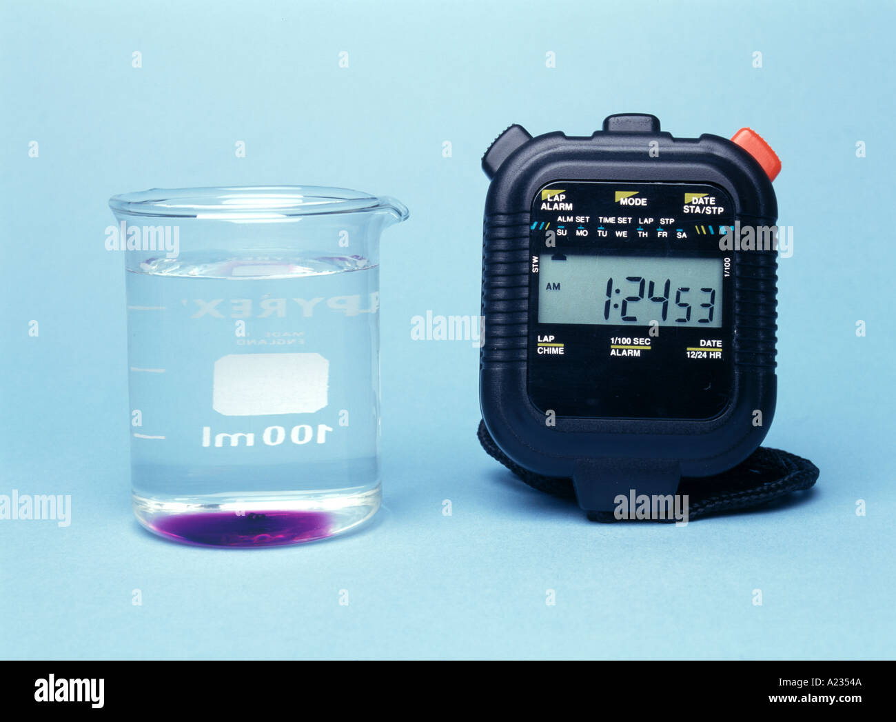 a crystal dissolving in water beside a stopwatch second in a series of three see also A2354B and A23549 Stock Photo