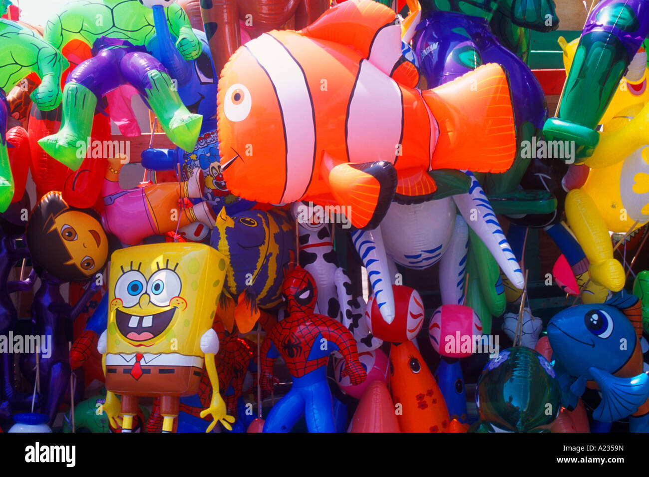Toy balloons for sale at Coney Island Amusement Park fair grounds multiple toy balloons spongebob squarepants yellow balloon and orange fish balloon Stock Photo