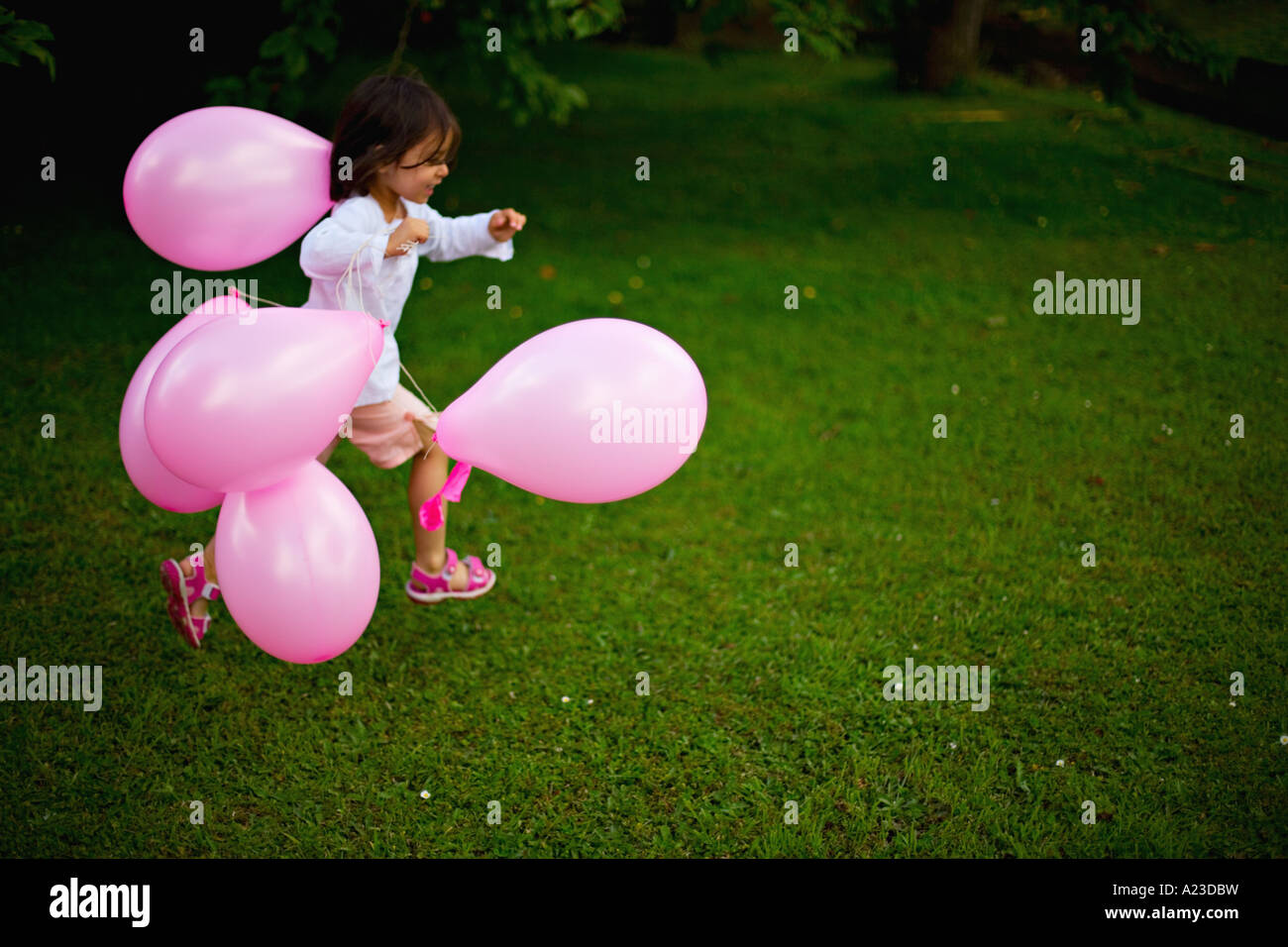 Girl runs with pink balloons Stock Photo