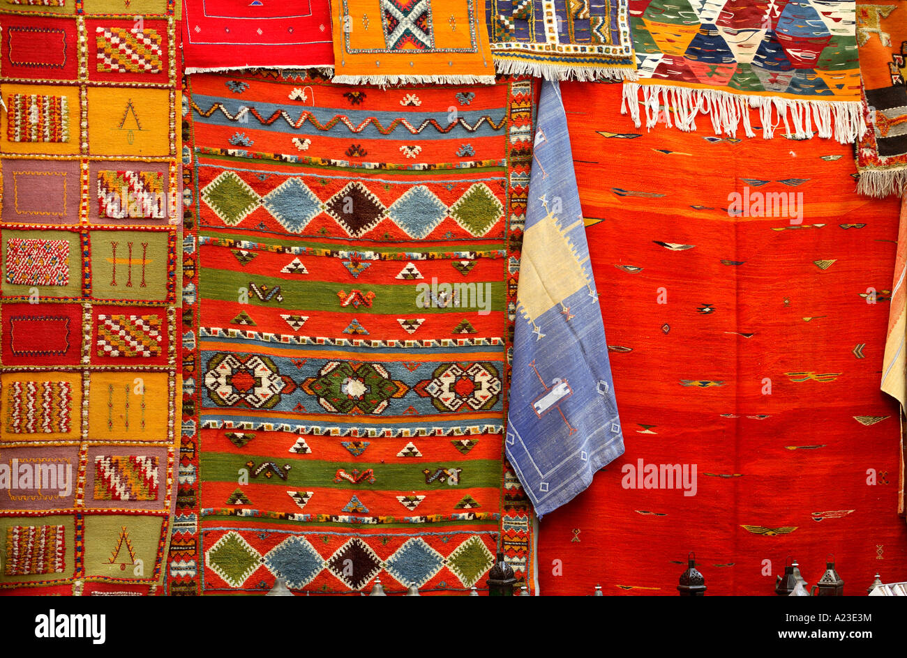 brightly coloured traditional moroccan rugs hanging from a shop front