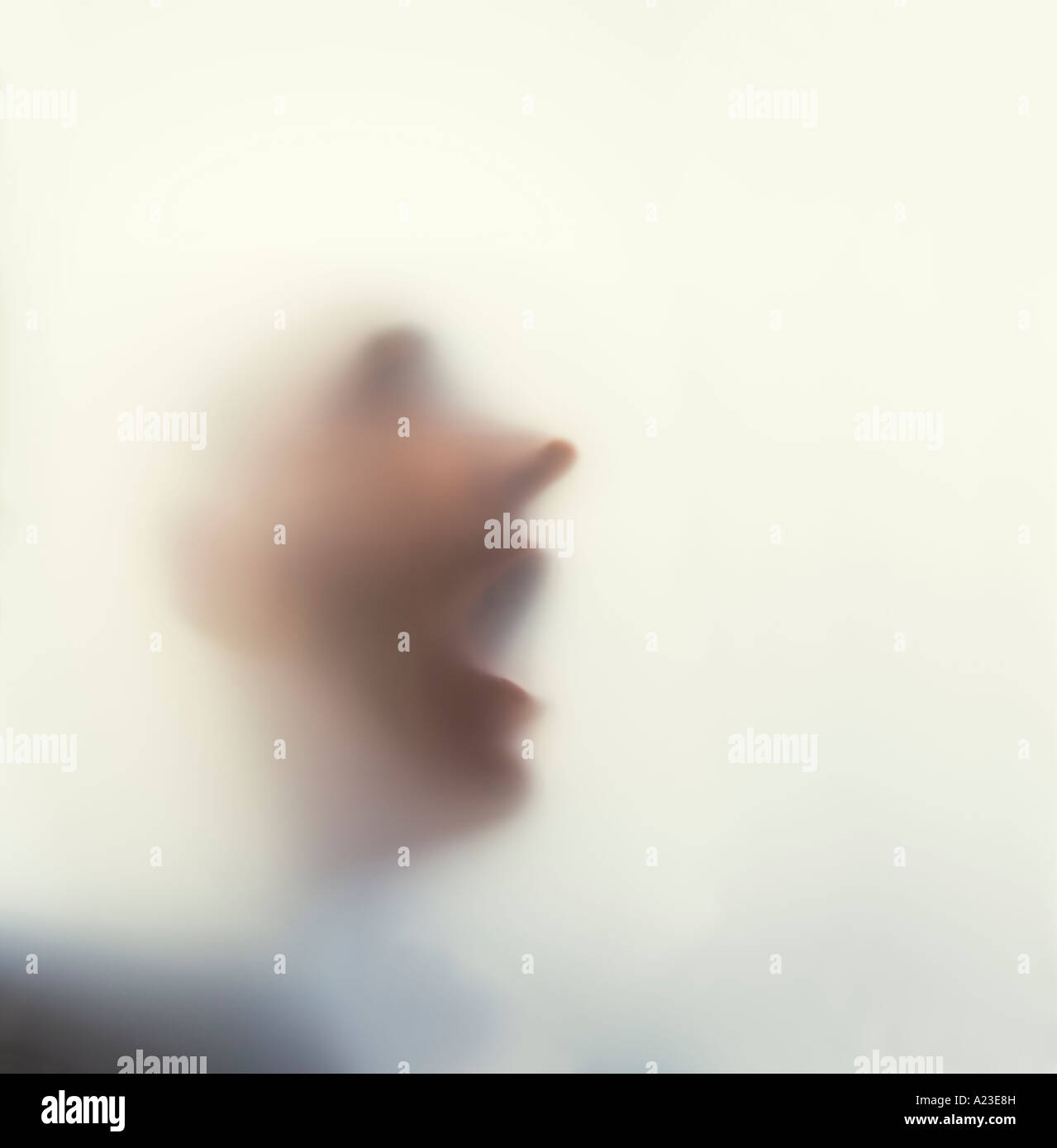 Man with face against frosted glass Stock Photo