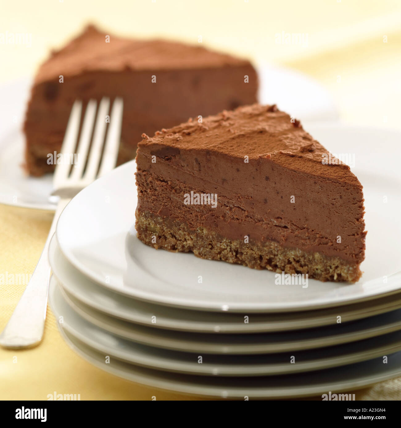 Chocolate Torte Gateau With Biscuit Base On Pile Of Plates With Fork Stock Photo Alamy