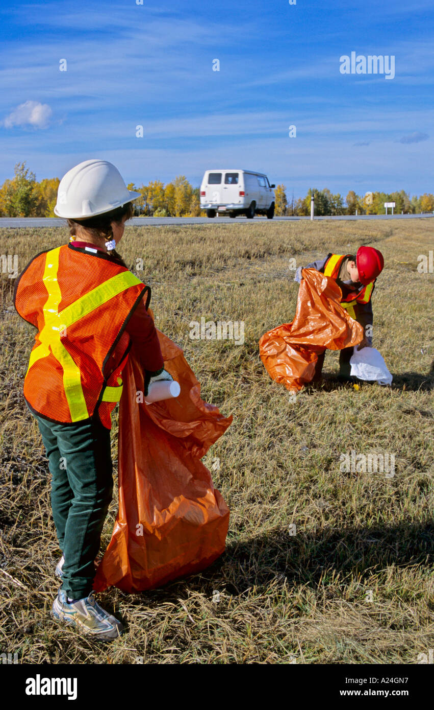 Children picking trash beside highway Stock Photo