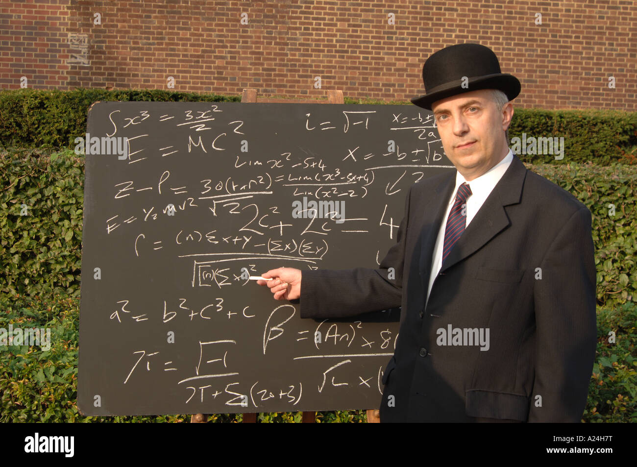 City gent at blackboard with complex equations Stock Photo
