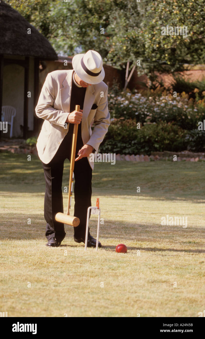 Croquet game players in Victorian Dress Lawn Grass Hoop Ball Mallet Man Woman Vicar hat Peg