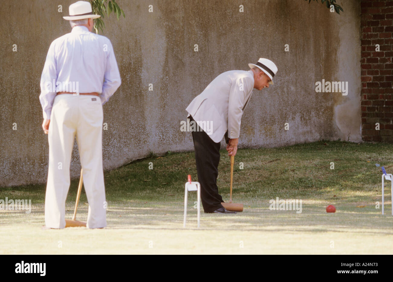 Croquet game players in Victorian Dress Lawn Grass Hoop Ball Mallet Man