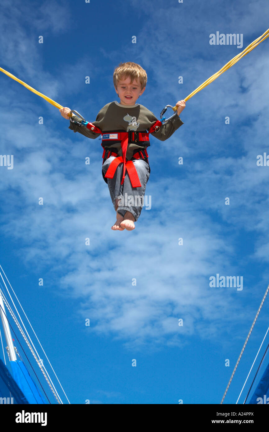 young child bouncing on bungee trampoline gymnastic apparatus against