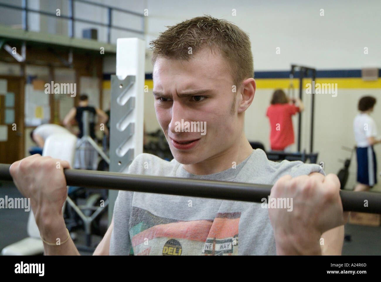 Students work out in a weight training room in a high school class ...