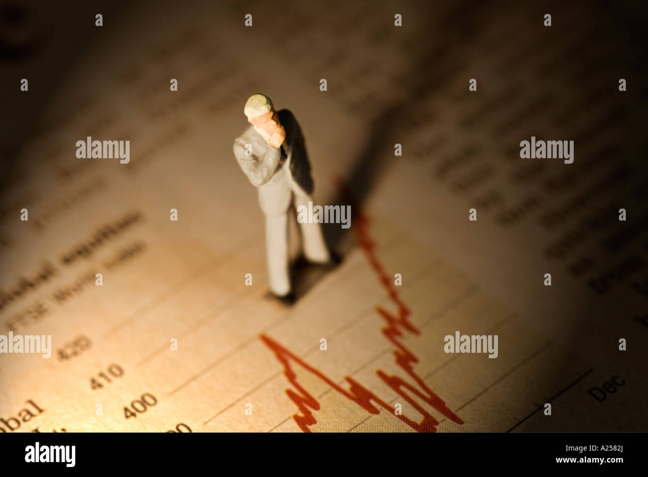 Miniature businessman standing on financial newspaper Stock Photo