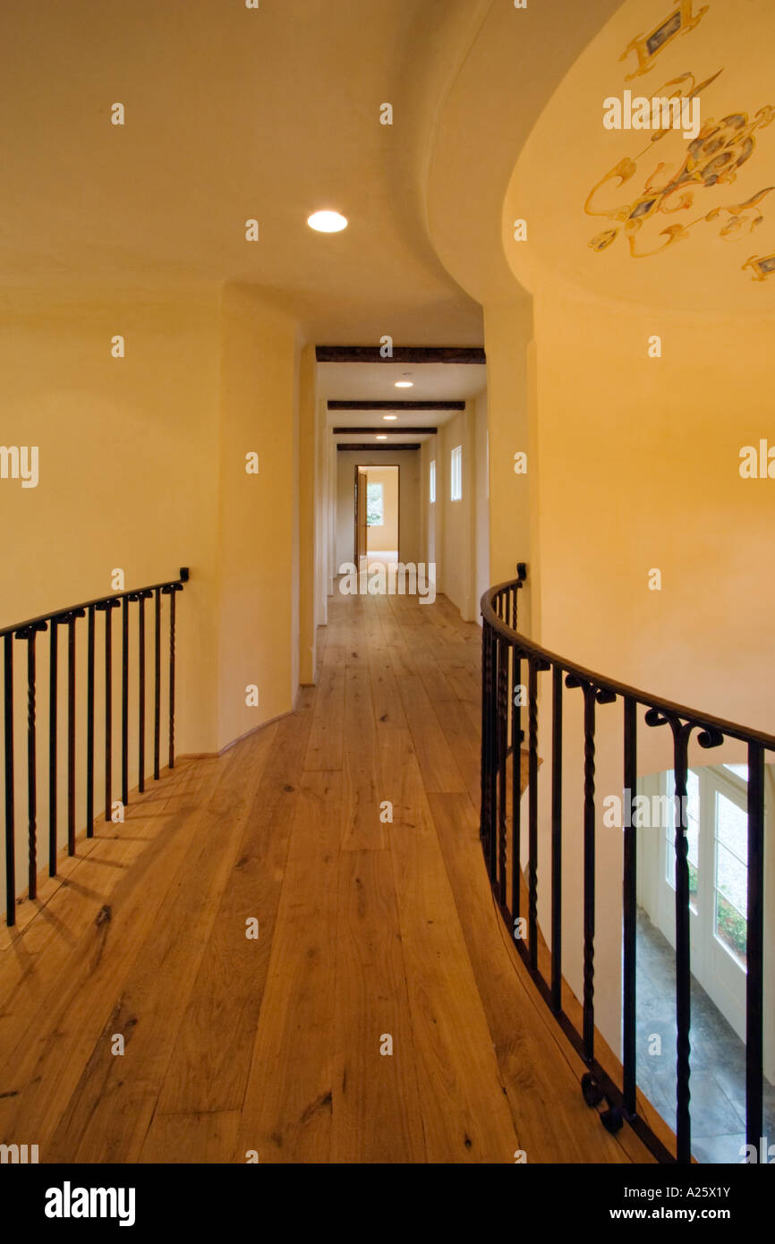 HARDWOOD FLOOR and wrought iron RAILING in the upstairs hallway of a