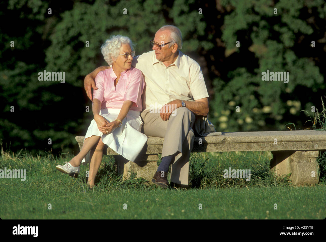elderly couple sitting on park bench Stock Photo - Alamy