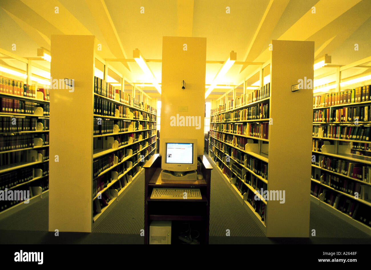VIEW DOWN ROWS OF SHELVES IN LIBRARY WITH COMPUTER IN FRONT Stock Photo ...