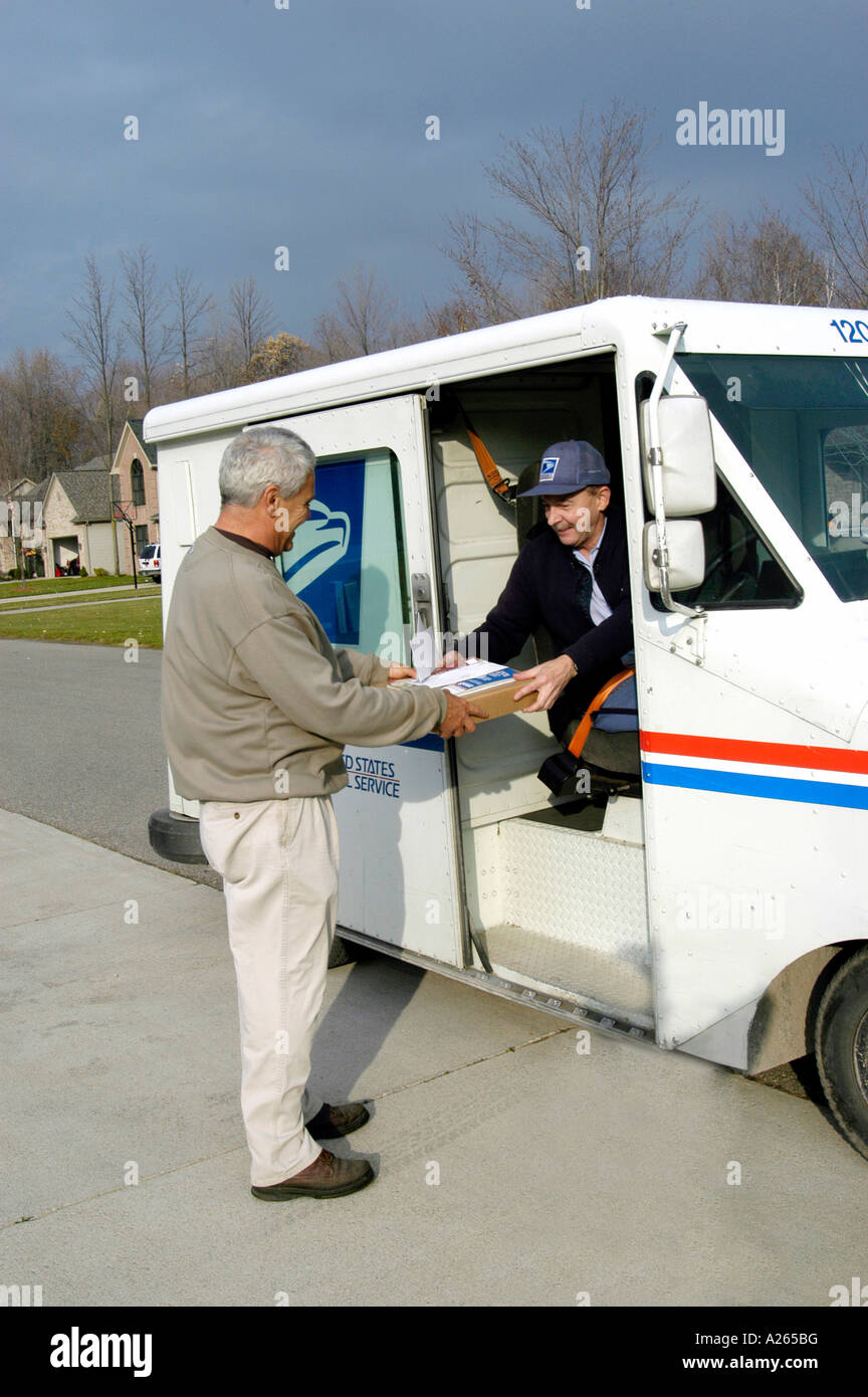 Postal carrier driving a mail truck delivers mail to male home owner