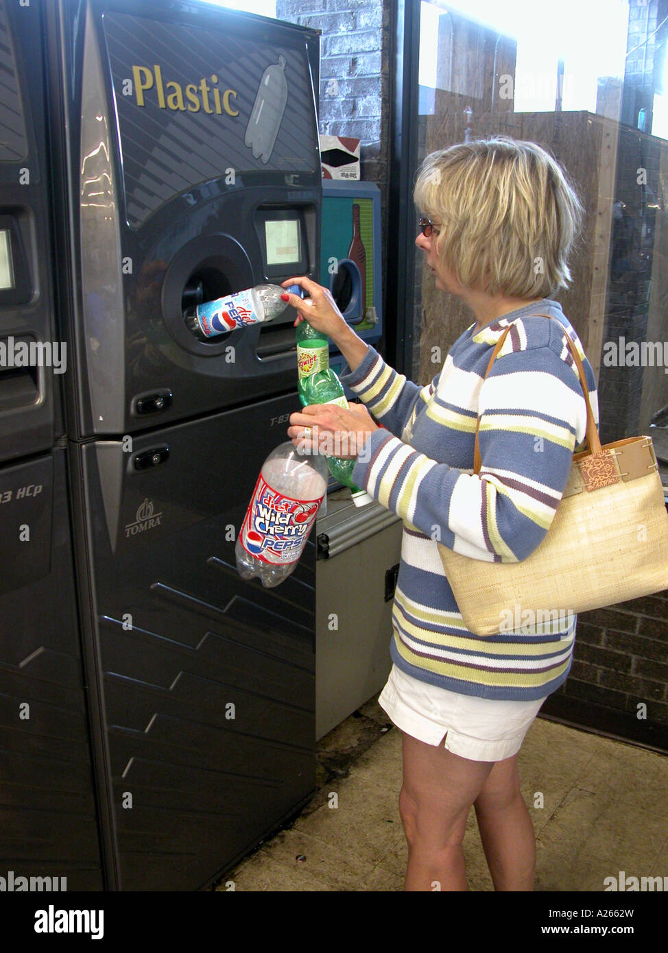 Adult female recycles plastic bottles at a grocery store in Michigan