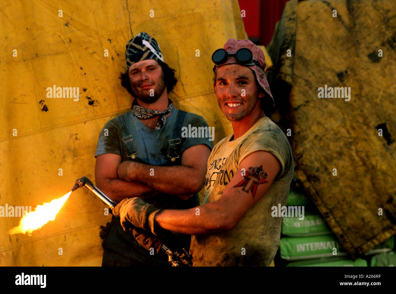 Two oil field workers take a break from a routine welding project to pose for a portrait together on a rig in South Texas. Stock Photo