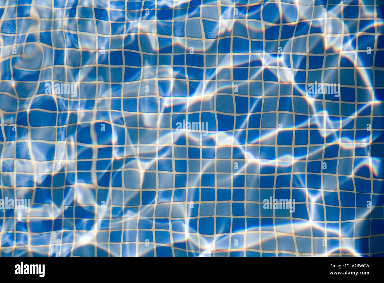 Light playing on rippled water in tiled swimming pool Stock Photo