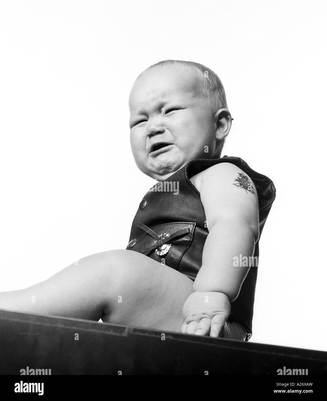 Baby boy (6 months) wearing leather vest. Stock Photo