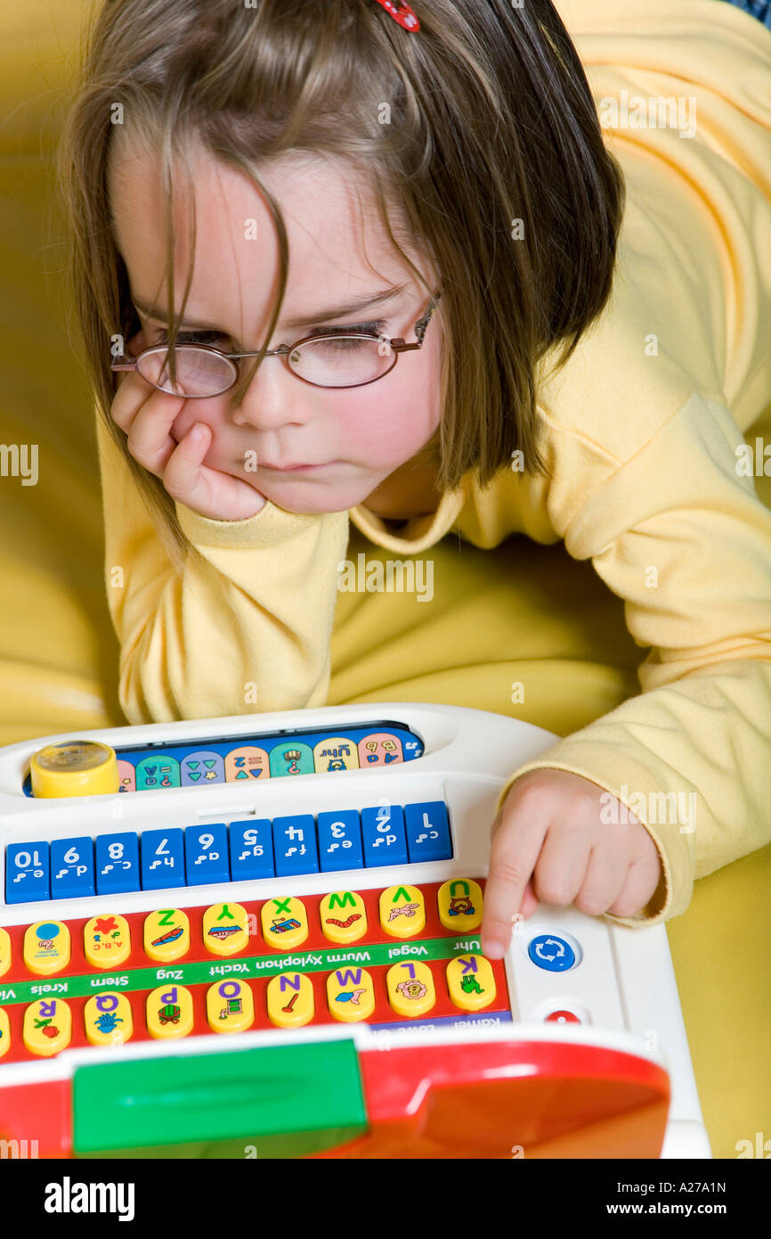 A four years old girl playing with a kids computer Stock Photo