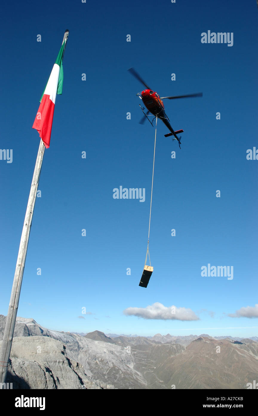 Helicopter transporting load of lumber on rope Julius  Payer mountain hut Mount Ortler Alto Adige South Tyrol Ital Stock Photo