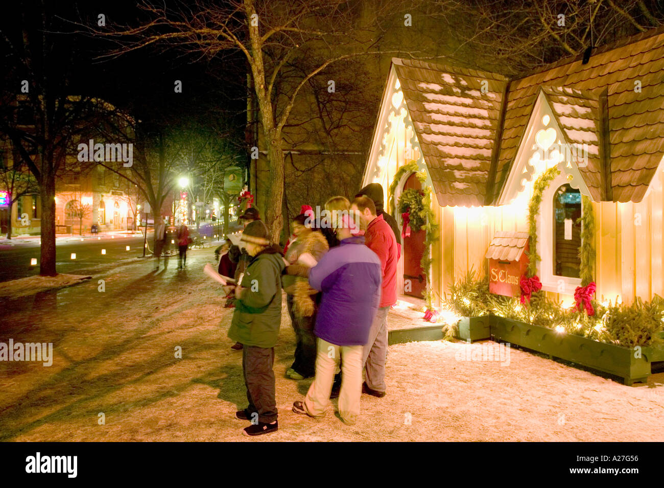 Carollers sing Christmas carols on Main Street in front of Santa s