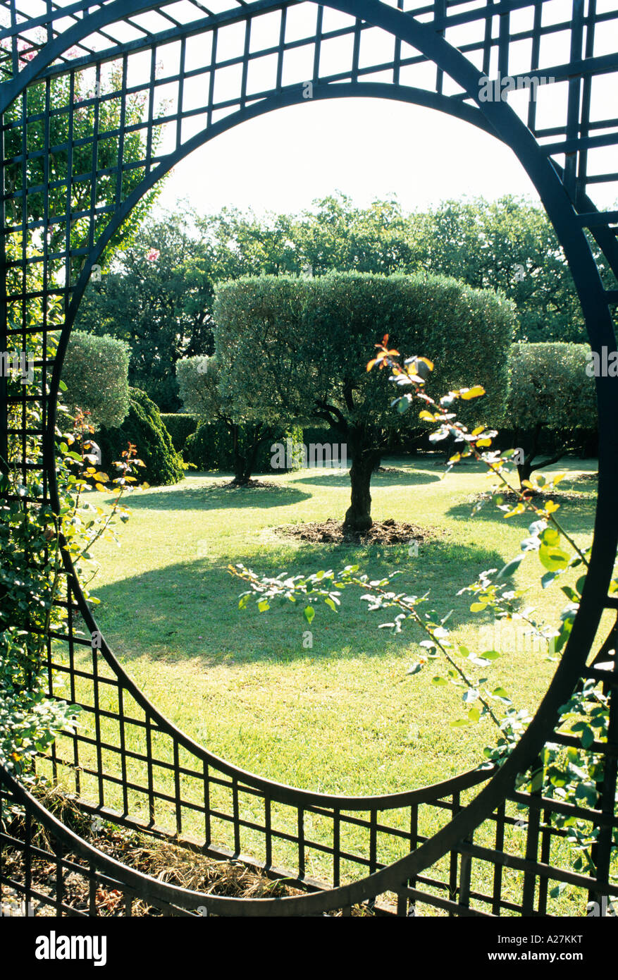 View through circular trellis into Provençal garden orchard Stock Photo