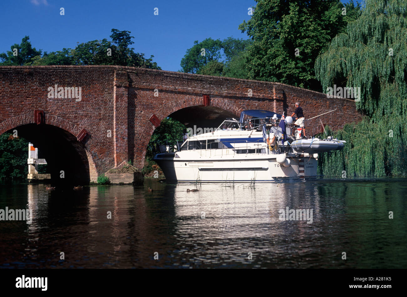 Maneuvering a large motor cruiser through the arch of Sonning Bridge on the River Thames, Sonning, Berkshire, England Stock Photo