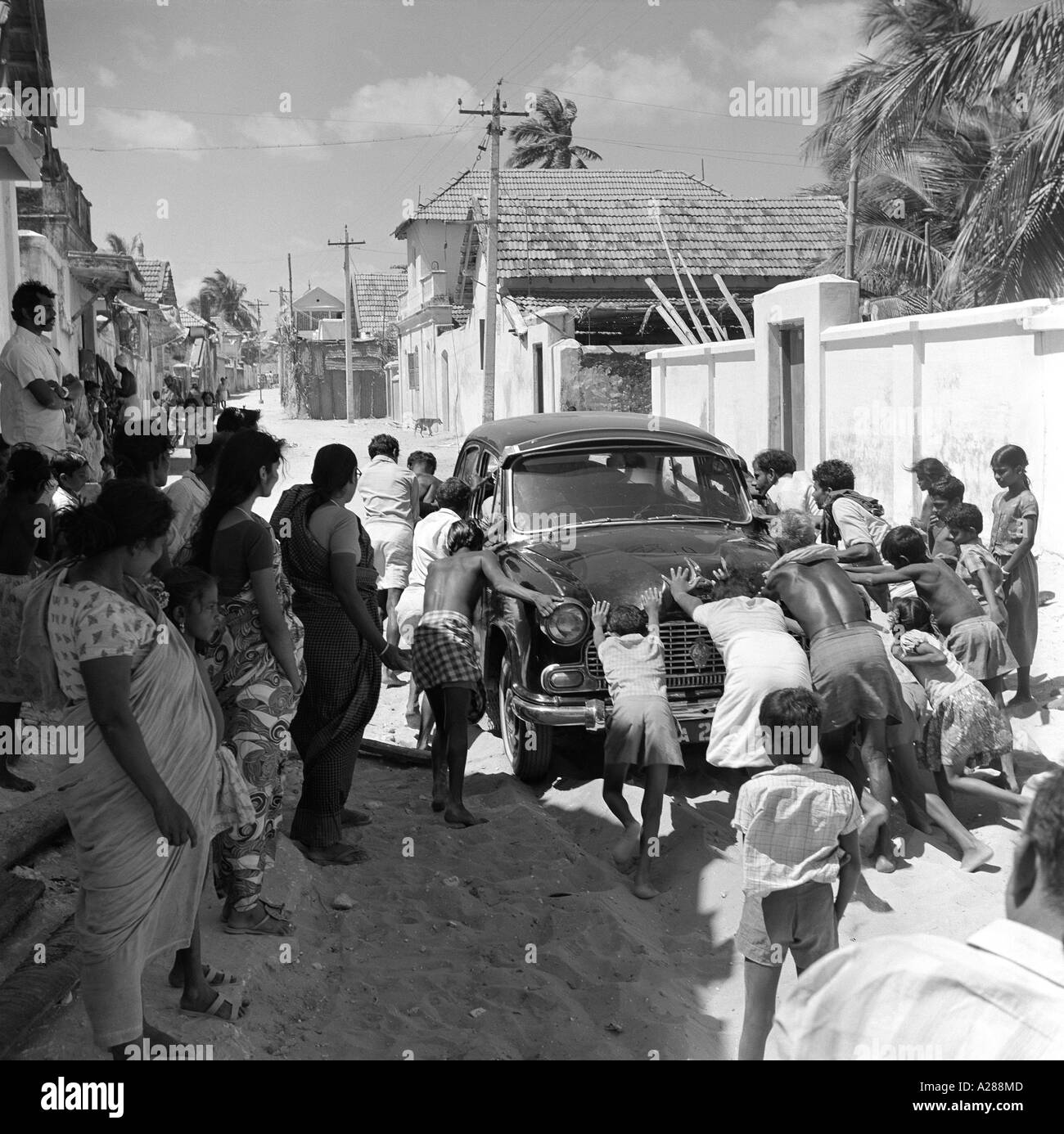 MAA76619 South Asian Indian children pushing stalled Ambassador car India Stock Photo