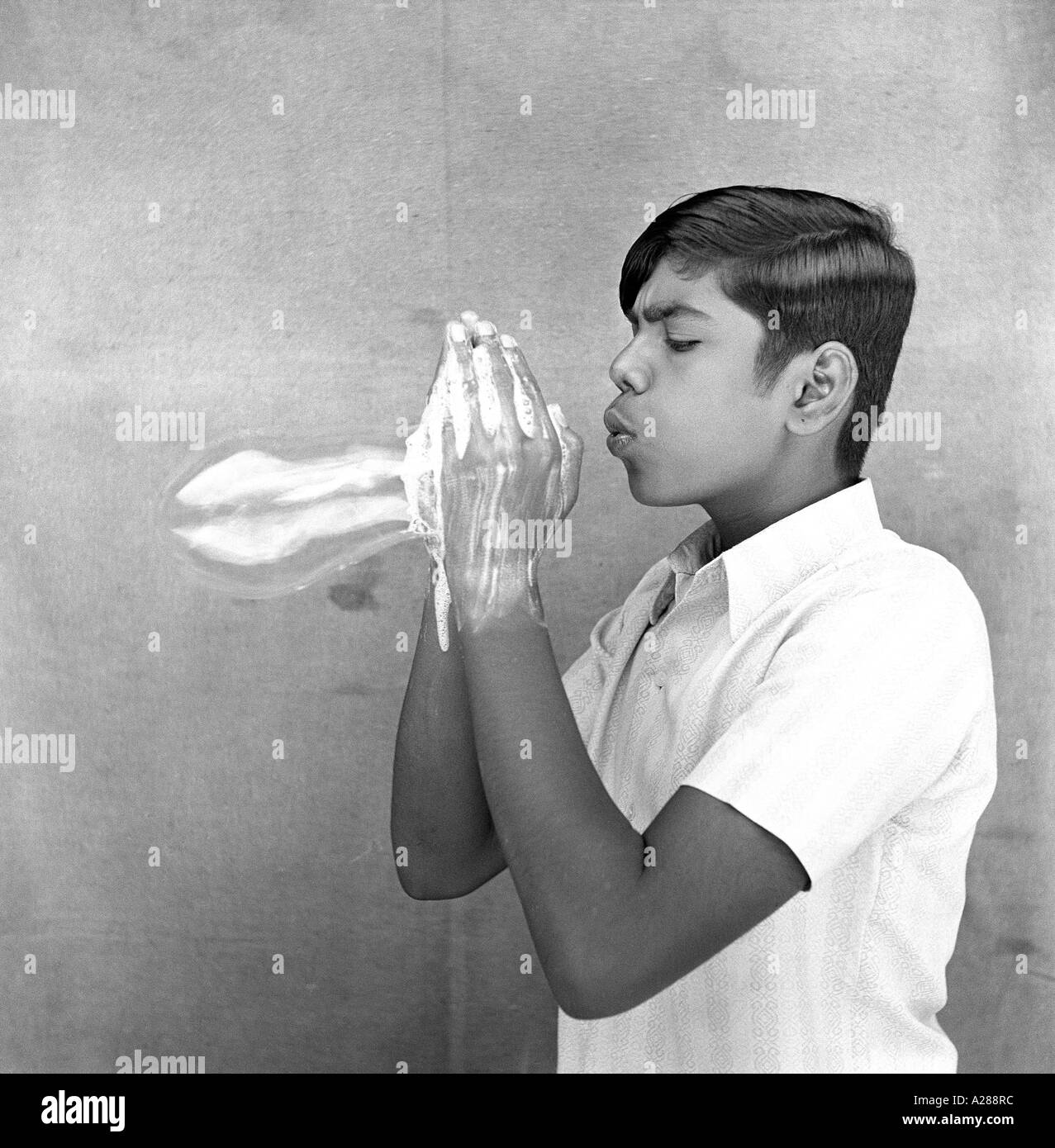 boy blowing soap balloon Stock Photo