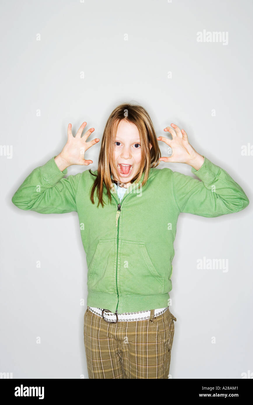 PORTRAIT OF 11 YEAR OLD GIRL WITH HANDS UP GRIMACING Stock Photo