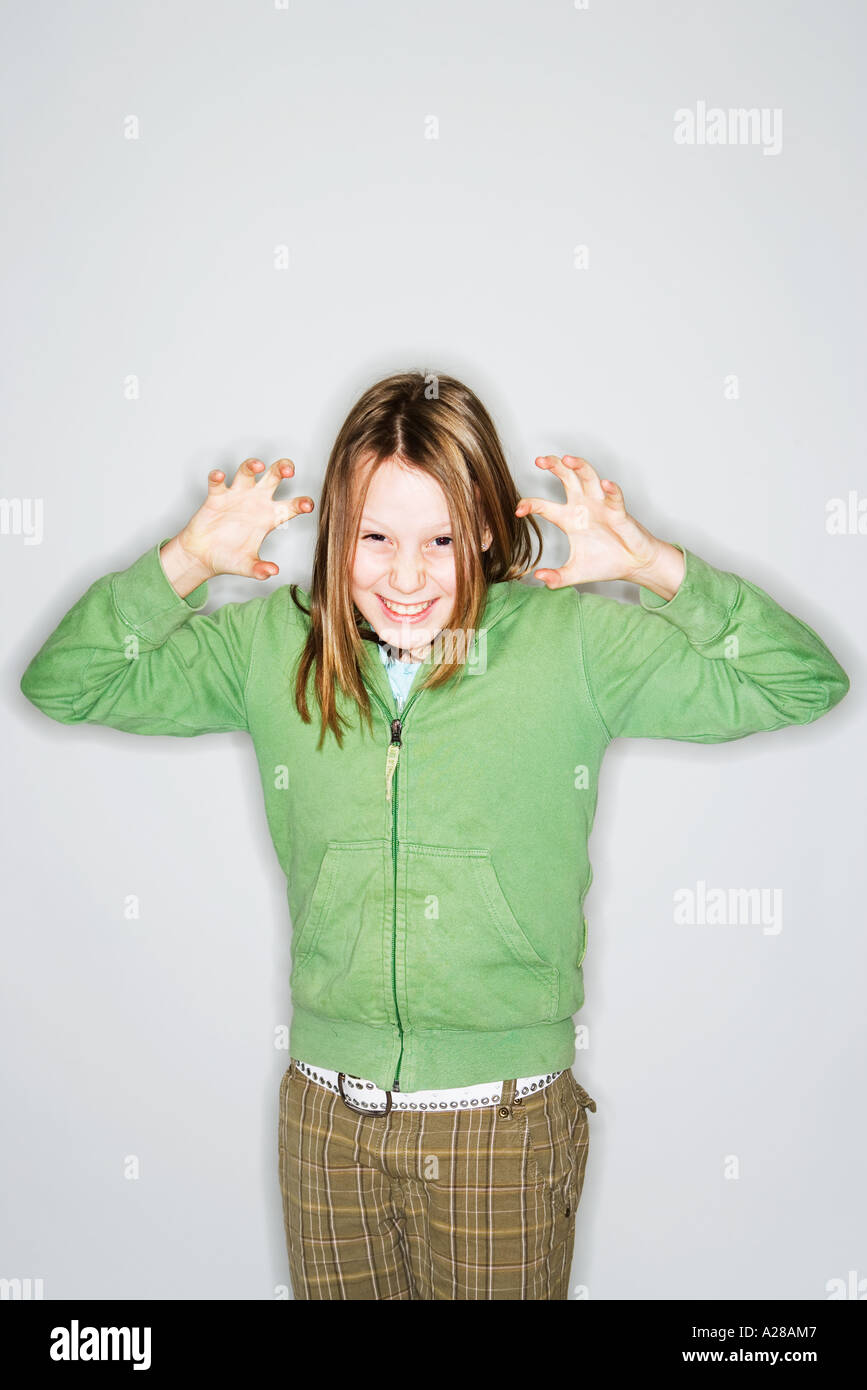 PORTRAIT OF 11 YEAR OLD GIRL WITH HANDS UP GRIMACING Stock Photo