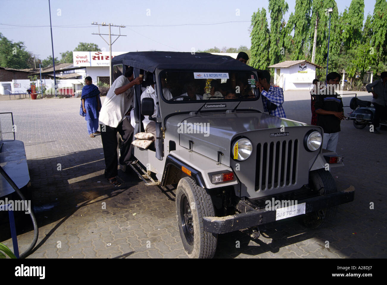 A Mahindra Commander jeep, used for public transport, is being refuelled at a petrol or gas station in rural Gujarat India Stock Photo