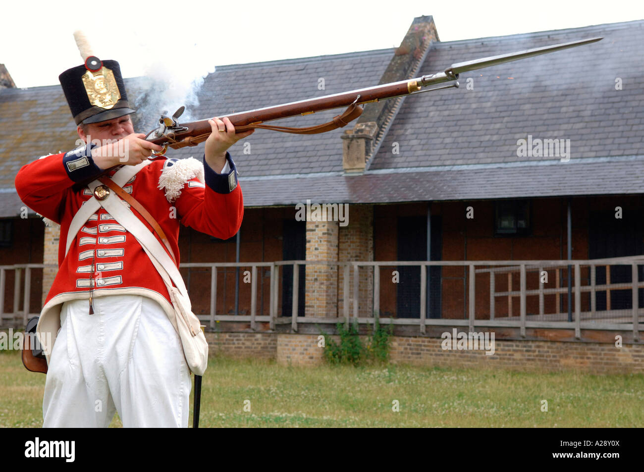 Man in historic English army soldier uniform shooting a Rifle with a Bayonet Stock Photo