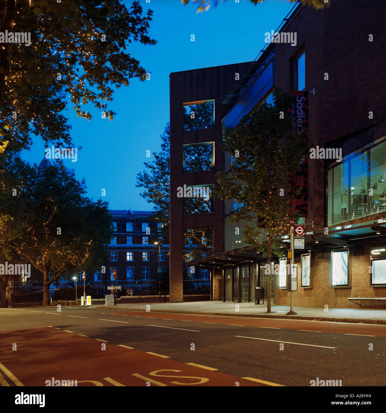 dusk shot front façade of Sadlers Wells Thetre, London; inc road, trees, disused Thames Water building in background Stock Photo