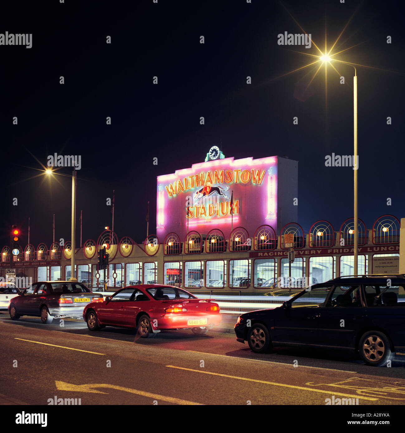 night shot front façade of Walthamstow Dog Racing Track, London; inc neon  signage, carpark, street lights and traffic Stock Photo