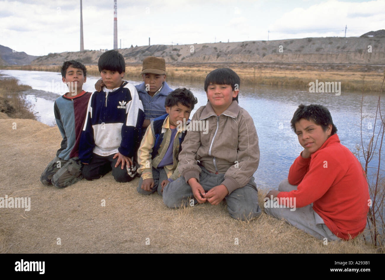 Six boys pose on the bank of the Rio Grande River in Ciudad Juarez Mexico with El Paso Texas USA in the background Stock Photo