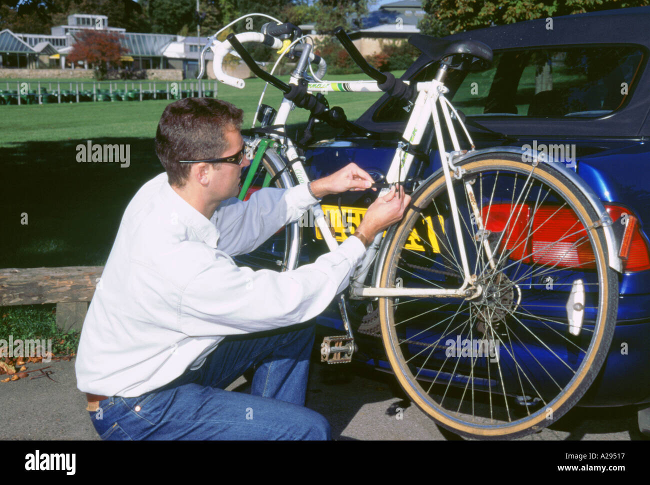 Man attaching bike to bike rack on car 